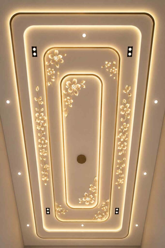 Luxury floral POP false ceiling design with glowing flower patterns, warm LED cove lighting, layered ceiling panels, and recessed spotlights in a modern home interior.